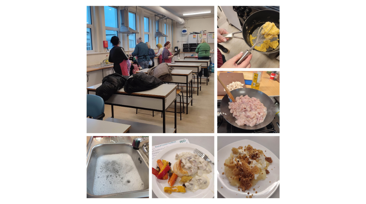 A classroom with people cooking, frying ingredients, a sink full of soapy water, and plates of prepared food with vegetables and sauces.